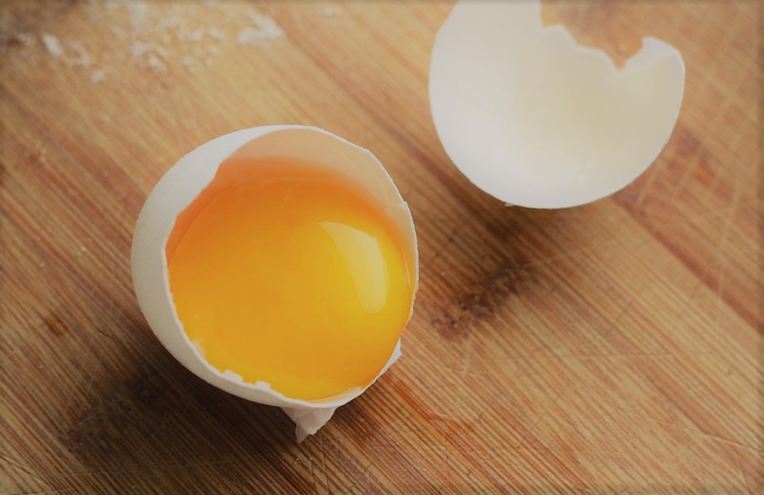 Czy kolor żółtka ma znaczenie? Pęknięte jajko z wylewającym się żółtkiem